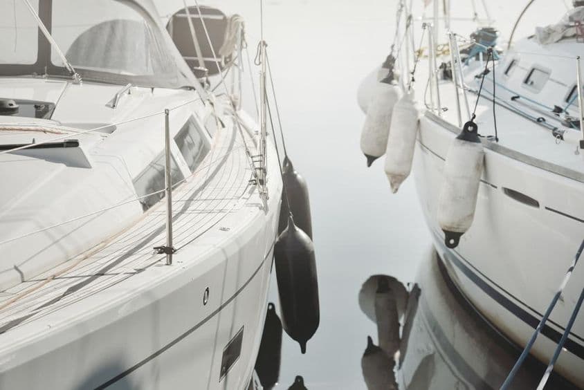 Weiße, moderne Segelyacht in einem Hafen vertäut.