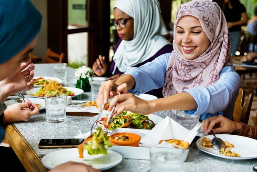 Muslimische Frauen speisen im Hijab.