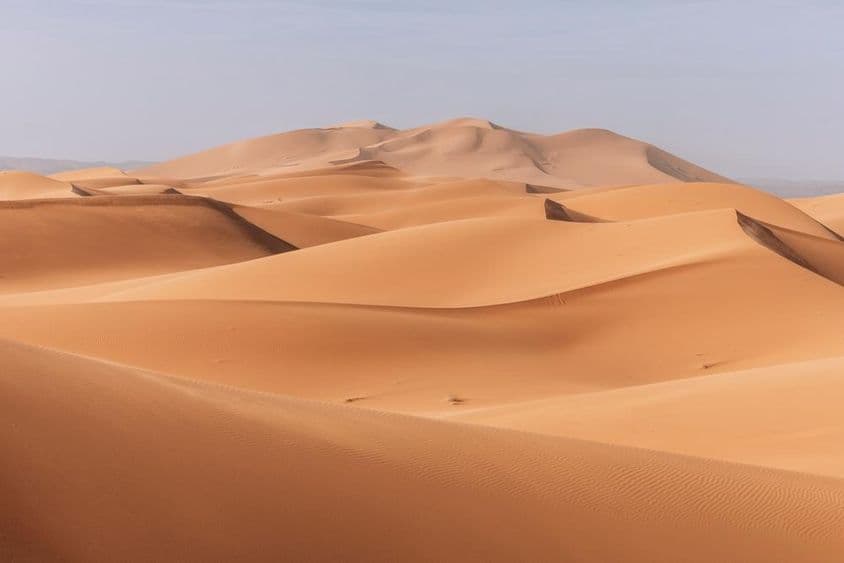 Majestätische Dünen, goldener Sonnenuntergang über einer ruhigen, stillen Landschaft.