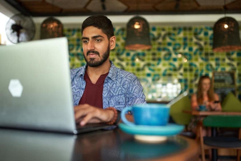 Indischer Mann arbeitet in einem trendigen Coworking Space.