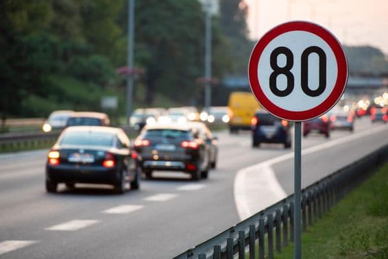 80 km/h Geschwindigkeitsbegrenzungsschild auf einer stark befahrenen Straße.