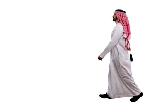 Arabischer Mann in traditioneller Kleidung spazierend.