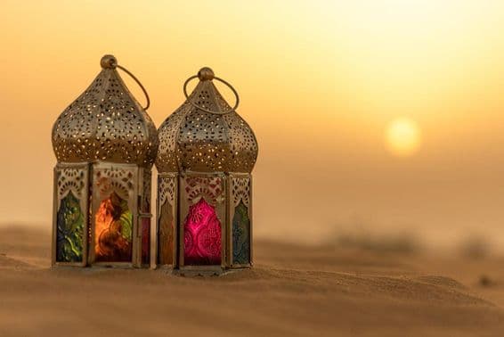 Arabische Laternen in einer Wüste bei Sonnenuntergang.