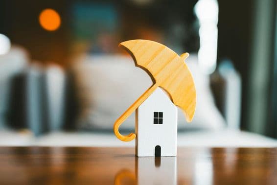 Modellschirm auf einem Holzhaus, Hausversicherung.