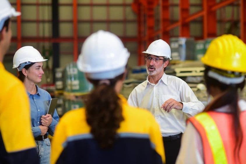 Manager Ingenieur hält eine Besprechung mit den Arbeitern.