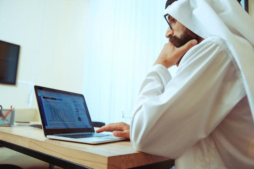 Arabischer Geschäftsmann arbeitet online in einem komfortablen Büro.