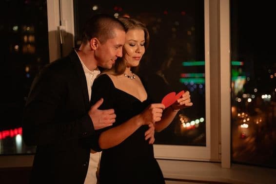 Liebespaar bei einem Valentinstagsdate, am Fenster stehend.