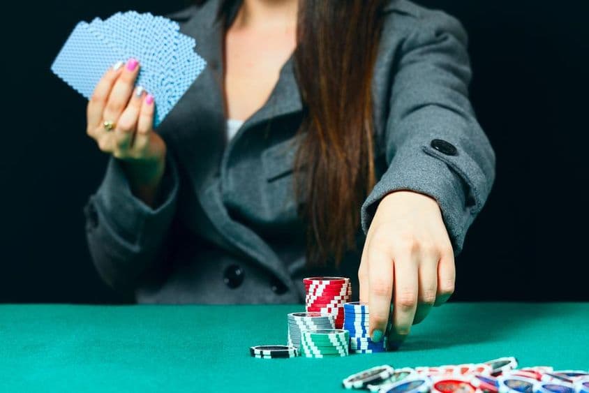 Blackjack in einem Casino, eine Frau platziert eine Wette mit Chips.