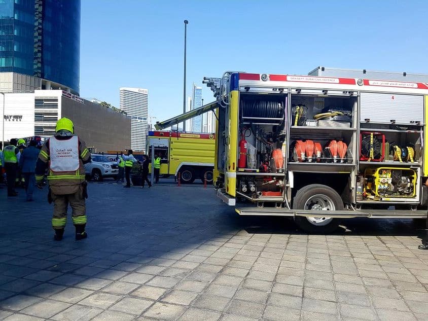 Einsatzleiter in der Nähe eines Feuerwehrautos während einer Evakuierungsübung.
