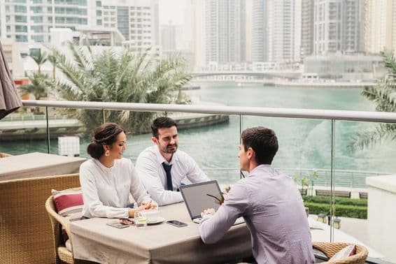 Geschäftstreffen auf einem modernen Balkon in der Dubai Marina.