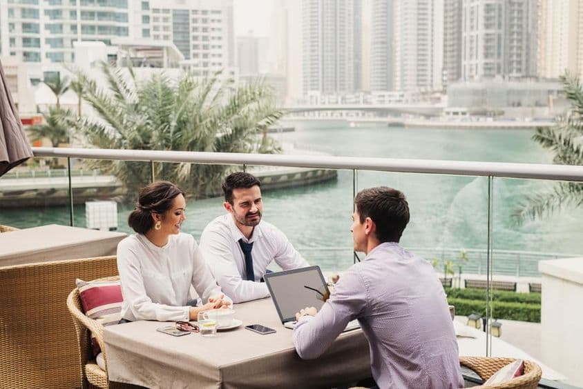 Geschäftstreffen auf einem modernen Balkon in der Dubai Marina.