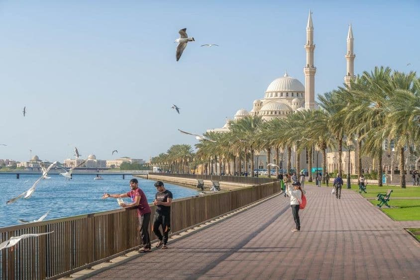 Sharjah mit der Al Noor Moschee, der Khalid-Lagune und dem Persischen Golf, mit Palmen und Stadtsilhouette.
