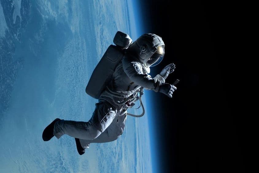 Weibliche Astronautin führt während eines Weltraumspaziergangs im tiefen Raum einen Videoanruf auf ihrem Telefon