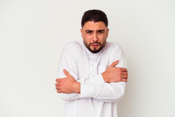 Junger Araber in traditioneller Kleidung zittert vor Kälte.
