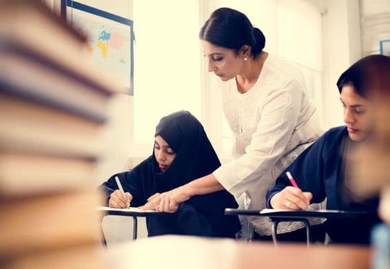 Muslimische Mädchen beim Lernen im Klassenzimmer.