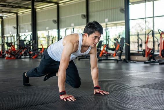 Mann im Fitnessstudio hebt Bein und bewegt sich