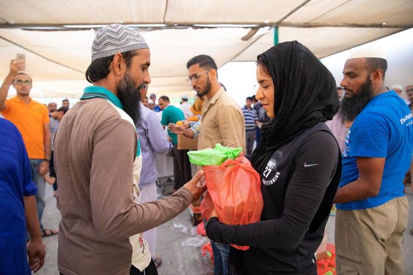 Freiwillige verteilen Lebensmittelpakete an Arbeiter während des Iftars.
