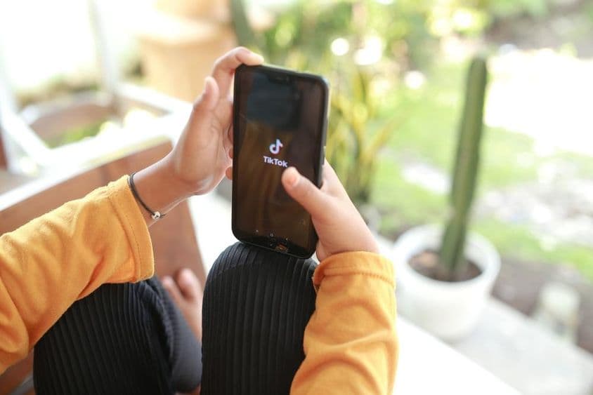 Ein Kind schaut TikTok-Medieninhalte auf einem Handy.