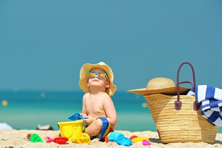Zweijähriger Junge spielt am Strand.