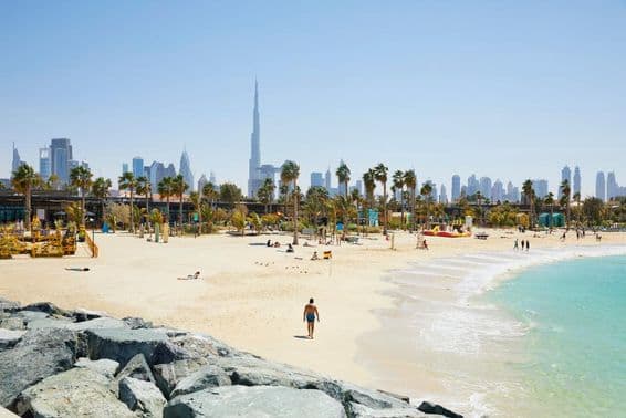 Strand mit der Skyline von Dubai im Hintergrund, Vereinigte Arabische Emirate.
