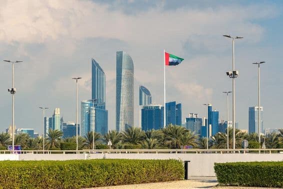 Abu Dhabis ikonische Skyline mit einem modernen Wolkenkratzer und sichtbar hervorgehobener Nationalflagge.