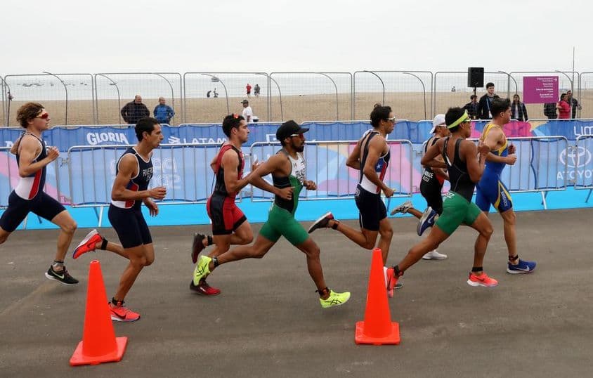 Triathlon-Teilnehmer laufen am Strand.