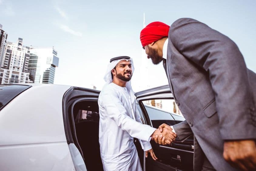 Arabisch-indischer Geschäftsmann diskutiert Zukunftspläne in Dubai in einer Limousine.