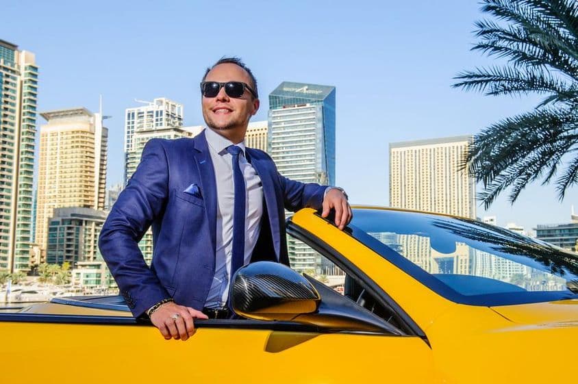 Erfolgreicher Geschäftsmann in einem gelben Cabrio.