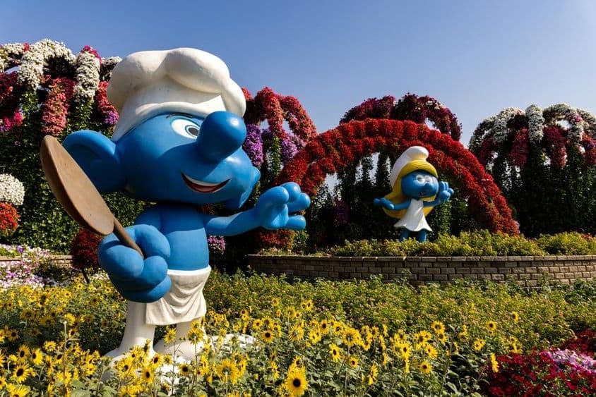 Lebensgroße Figuren der Schlümpfe in bunten Blüten im Dubai Miracle Garden.