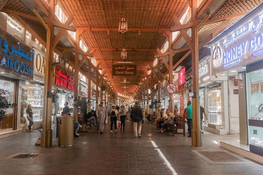 Touristen kaufen ein und erkunden Dubais Goldmarkt.