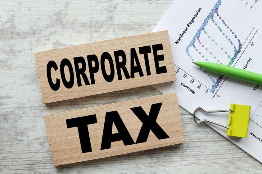 Unternehmenssteuer auf zwei Holzwürfeln.