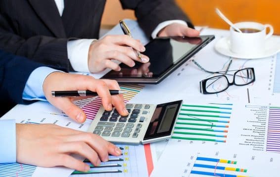 Diagramme, Taschenrechner, Tablet, fleißige Hände studieren die Daten.