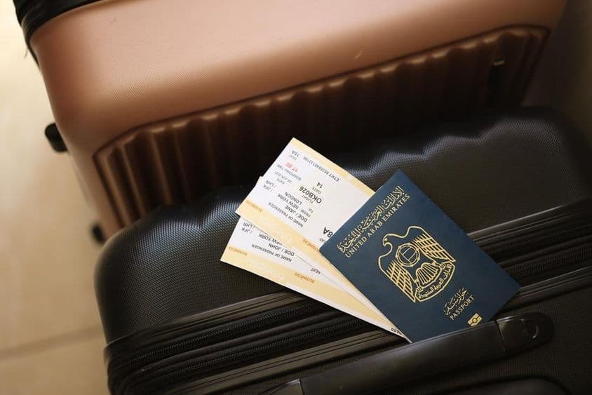 Vereinigte Arabische Emirate, ein Reisepass mit Tickets auf einem Koffer.