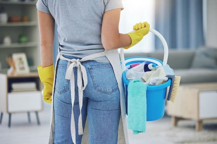 Haushaltshilfe arbeitet im Wohnzimmer.