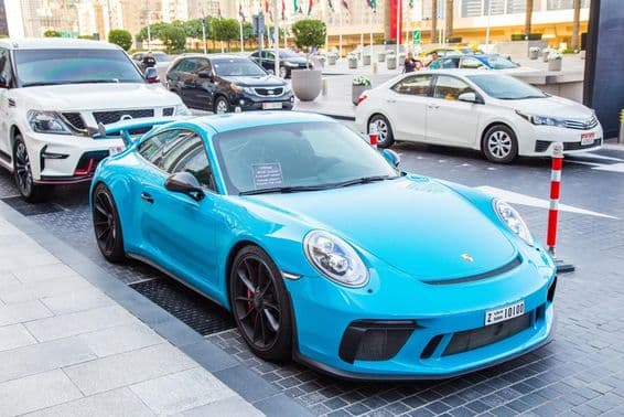 Dubai, blauer Porsche auf dem Parkplatz.