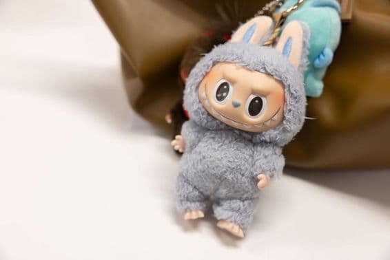 Ansicht des berühmten Popmart Labubu an einer Frauentasche.