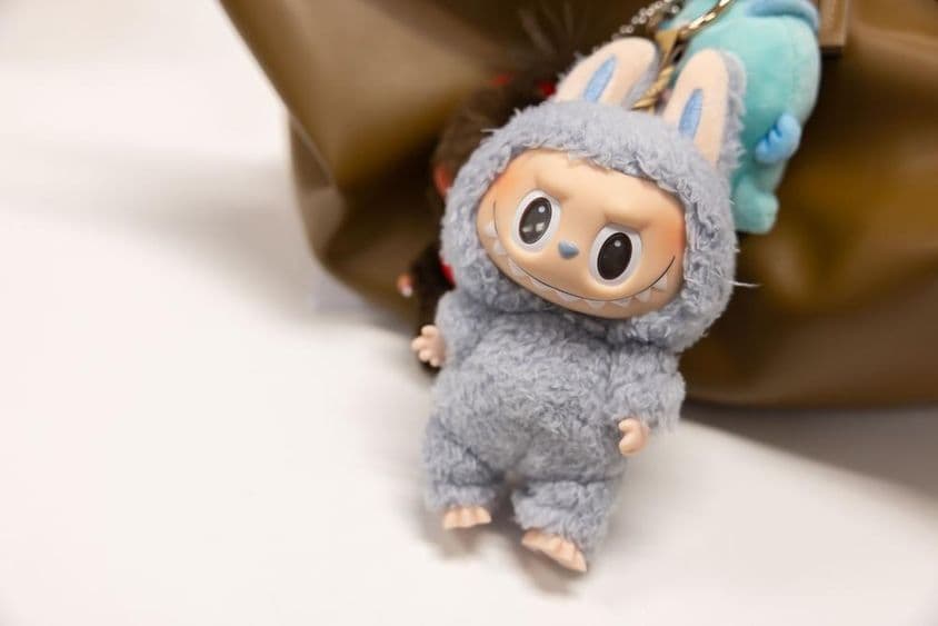 Ansicht des berühmten Popmart Labubu an einer Frauentasche.