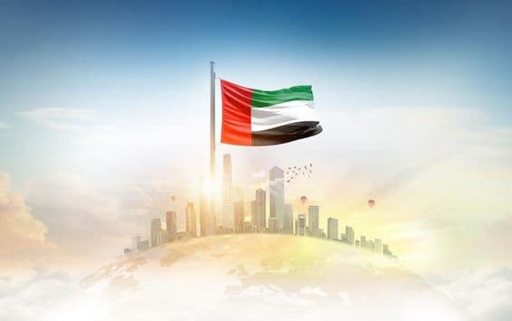 Flagge der Vereinigten Arabischen Emirate weht vor Wolkenkratzern.