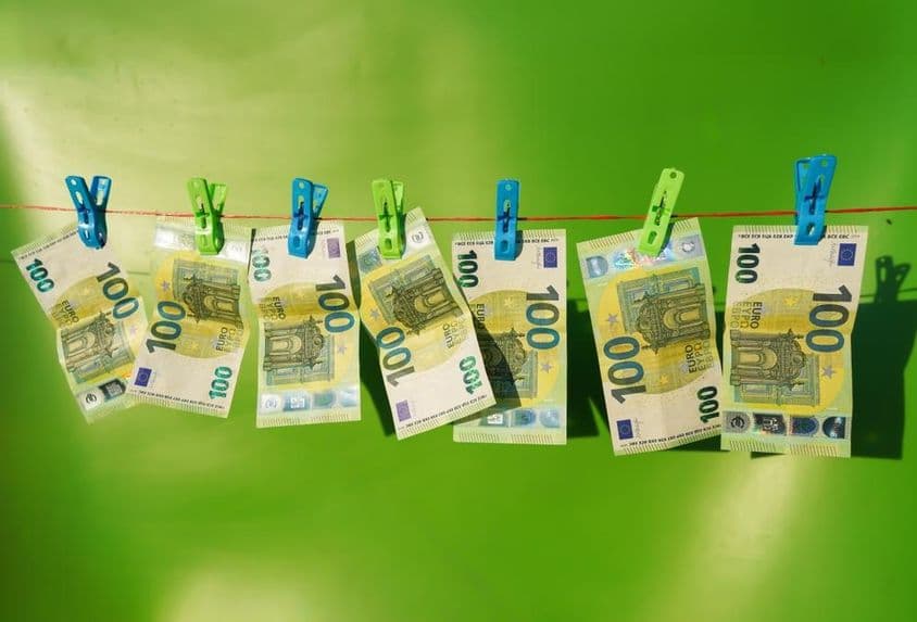 100-Euro-Scheine, die auf einer Wäscheleine trocknen.