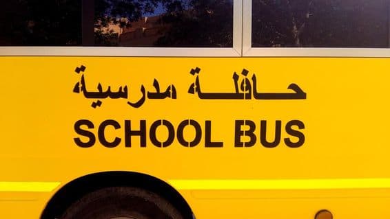 Eine Busseite mit Schulbus auf Arabisch geschrieben.