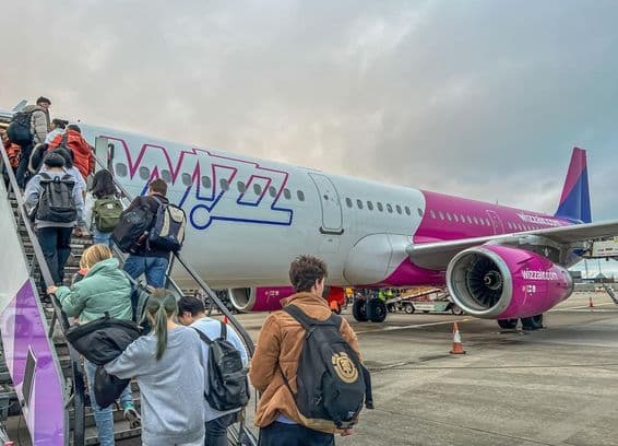 Rucksacktouristen steigen in ein Flugzeug der Fluggesellschaft Wizz Air