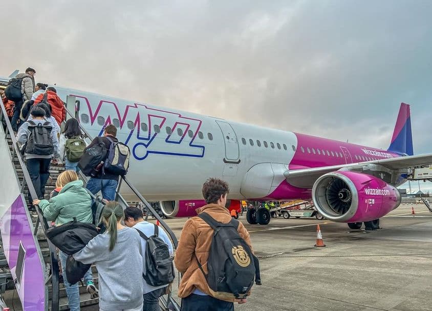 Rucksacktouristen steigen in ein Flugzeug der Fluggesellschaft Wizz Air