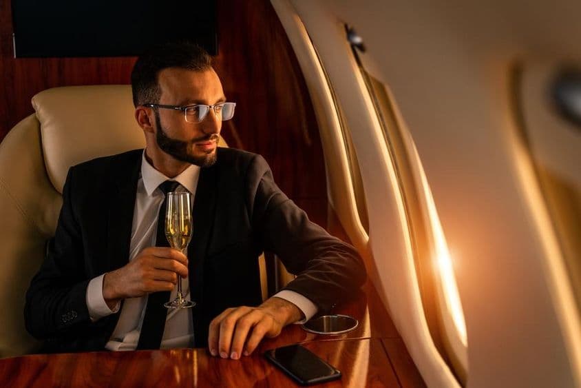 Geschäftsmann in elegantem Anzug, fliegt in einem exklusiven Privatjet.