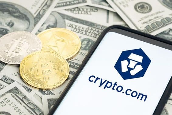 Crypto.com-Logo, Dollarnoten, sichtbare Bitcoin- und Ethereum-Münzen.