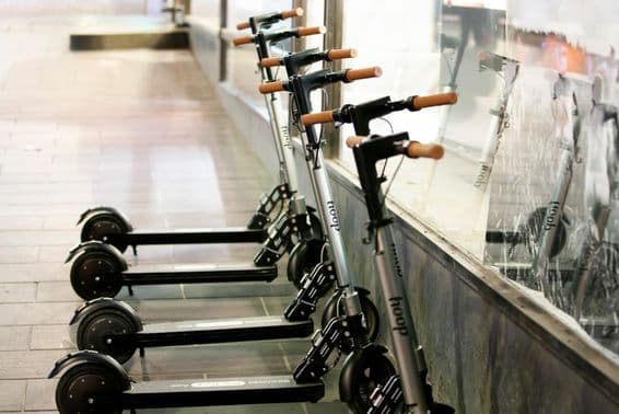 Silbergrauer mietbarer Elektroroller von Hoop.