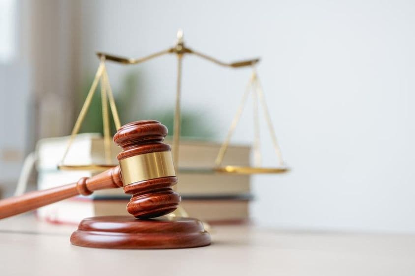 Ein hölzerner Richterhammer auf einer hölzernen Basis.