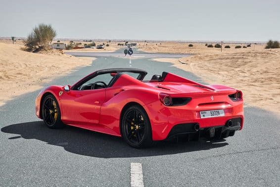 Roter Ferrari 488 auf einer verlassenen Wüstenstraße in Dubai.