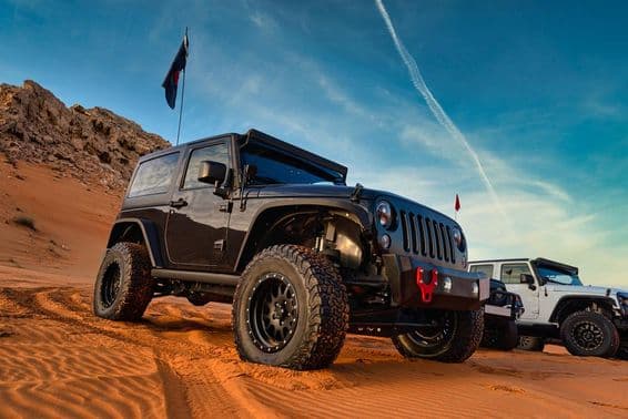 Jeep Wrangler Offroad-Abenteuer auf einer Sanddüne in Dubais roter Wüste.