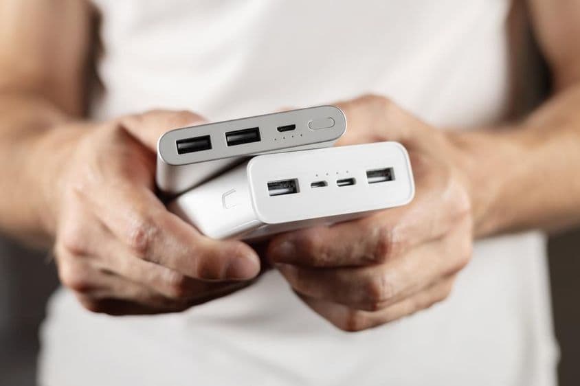 Zwei externe Batterien in der Hand gehalten.