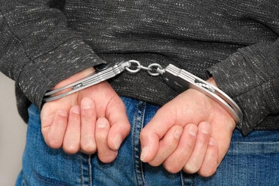 Ein Krimineller in Handschellen nach Festnahme.